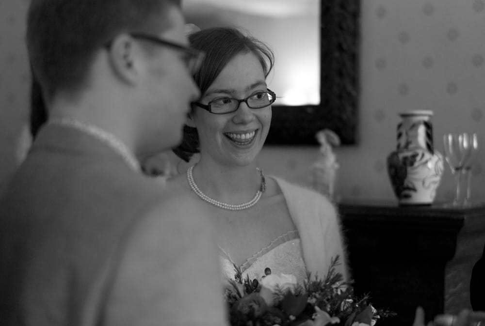 Black and white portrait of Catherine smiling beside Philip during reception at Weetwood Hall.