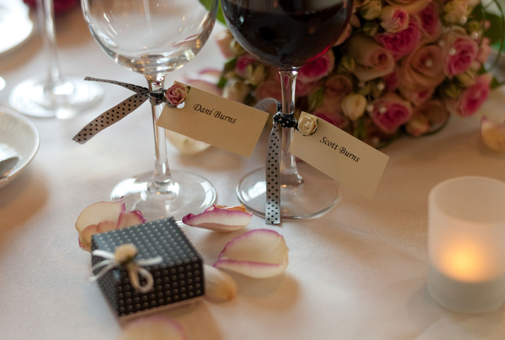 Dani and Scott’s name tags tied to wine glasses at the top table