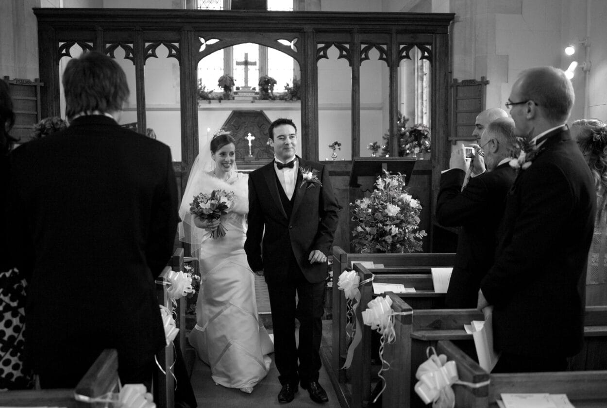 The couple begin their exit as the groom winks at family, captured in my warm storytelling Yorkshire style.
