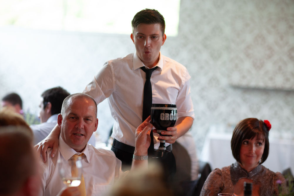 The groom makes his way around the tables with his goblet, chatting with guests.