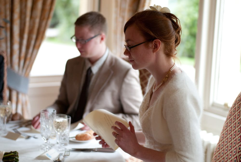 Bride and groom seated by the window at Weetwood Hall, Catherine in focus.
