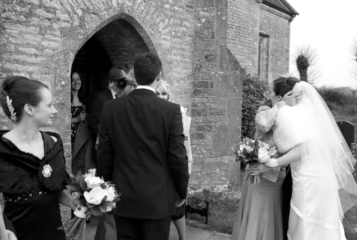 Guests greet the couple outside, wrapped against the cold.