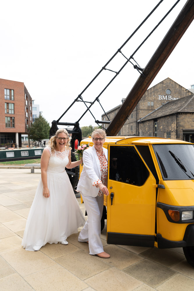 Couple posing by yellow prosecco van at Leeds Waterfront