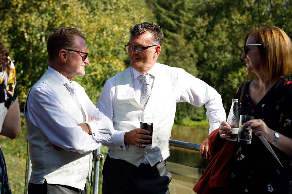 The fathers of the couple chat casually outside in the warm afternoon sunshine at Chevin Lodge.