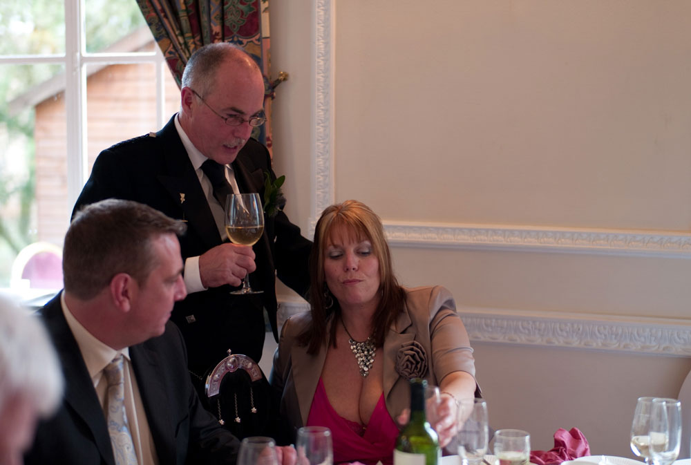 Scott’s father toasts with a smile, hand resting gently on his wife’s shoulder