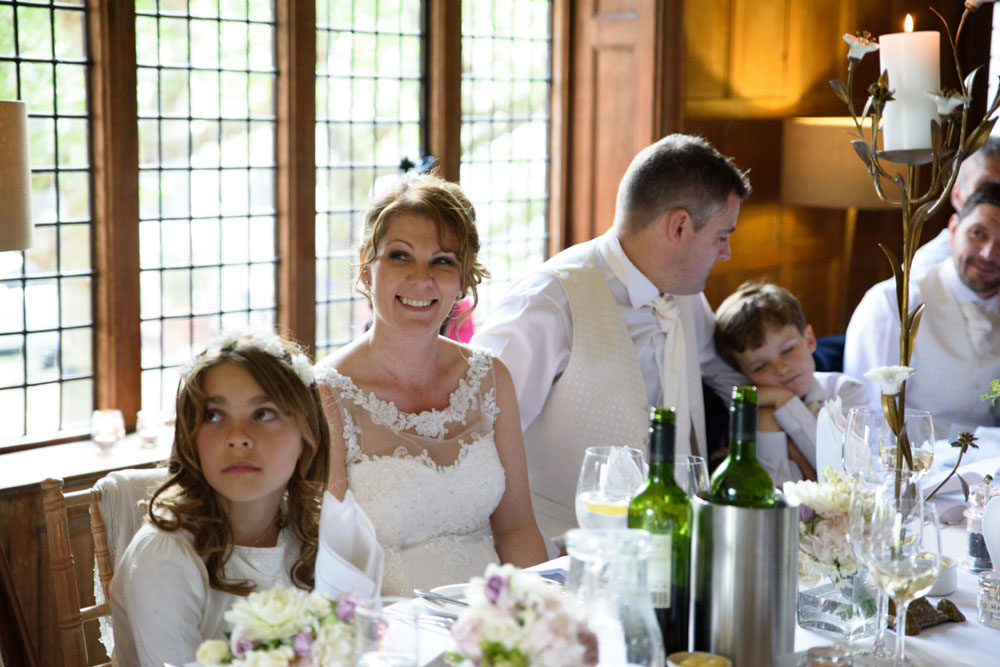 Seated at the top table, their son leans in, tired but content.