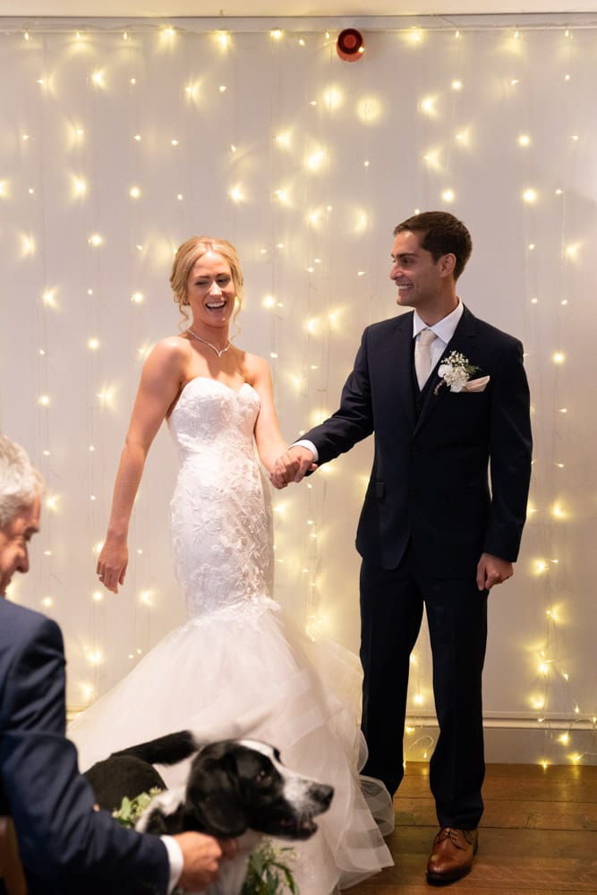 The newlyweds look back, smiling at family and friends.