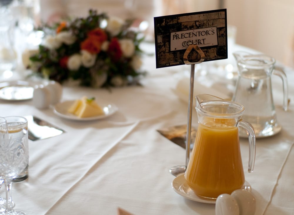 Table detail at Weetwood Hall wedding — place name “Placentor’s Court,” water, butter, and orange juice.
