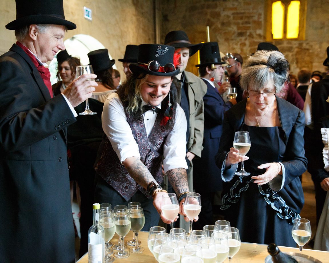 067 best man takes 2 champagne glasses from the table kirkstall abbey wedding linsey and chris