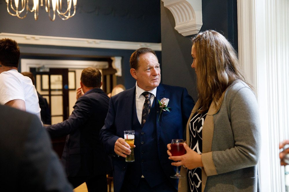 Groom chatting happily with guests