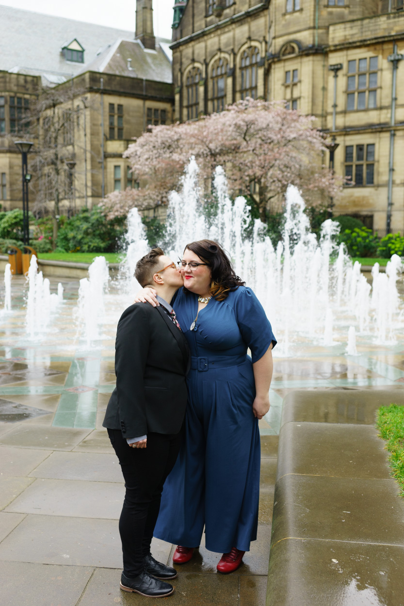 Kiss on the cheek by the fountains after the ceremony