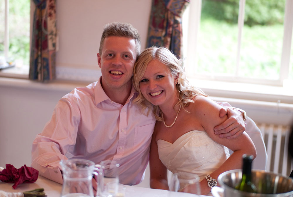 Dani and her brother smiling for a photo at the top table