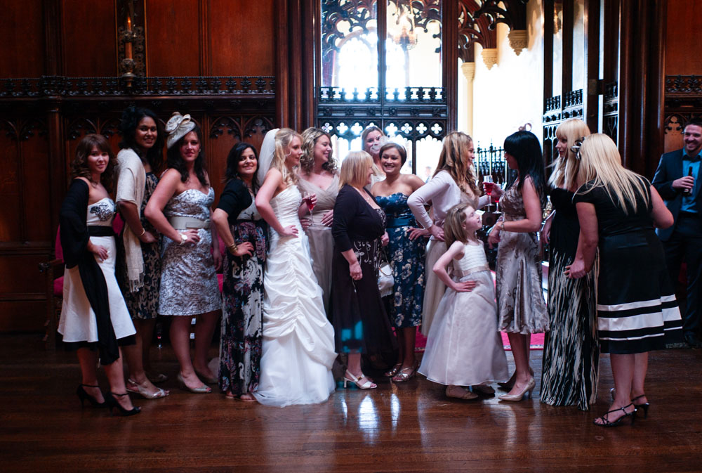 Bridesmaids et al laughing and chatting with hands on hips during a fun candid moment