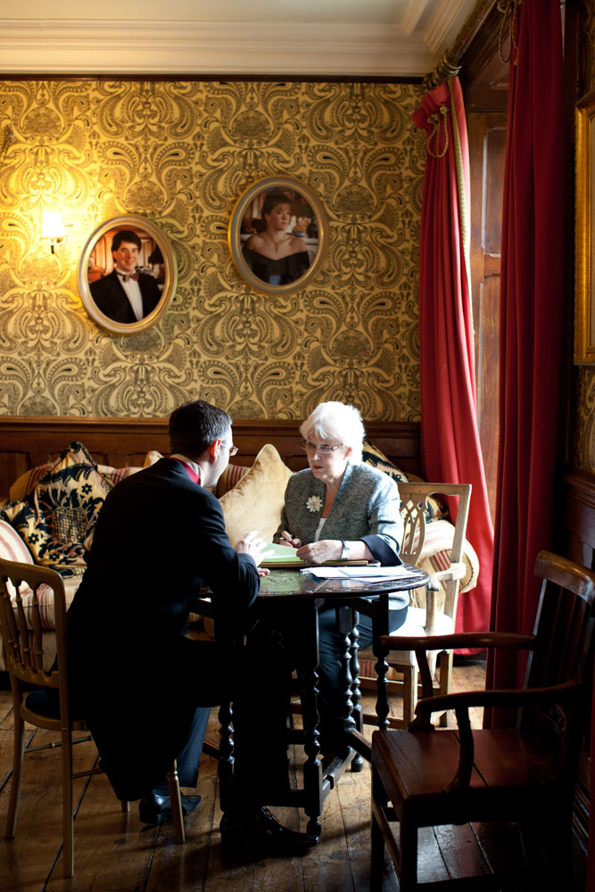 Groom chatting with the registrar ahead of the ceremony at Soughton Hall