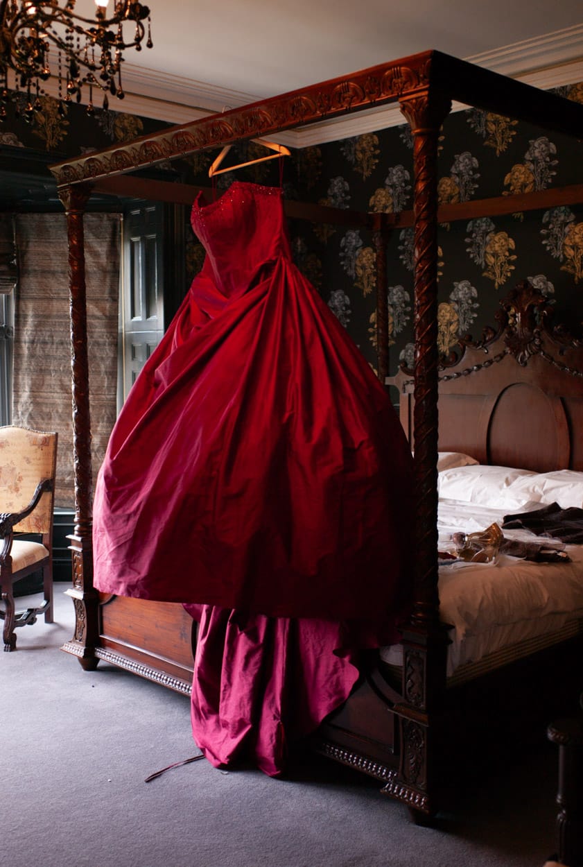 Nikki’s red wedding dress hanging from the four-poster bed.