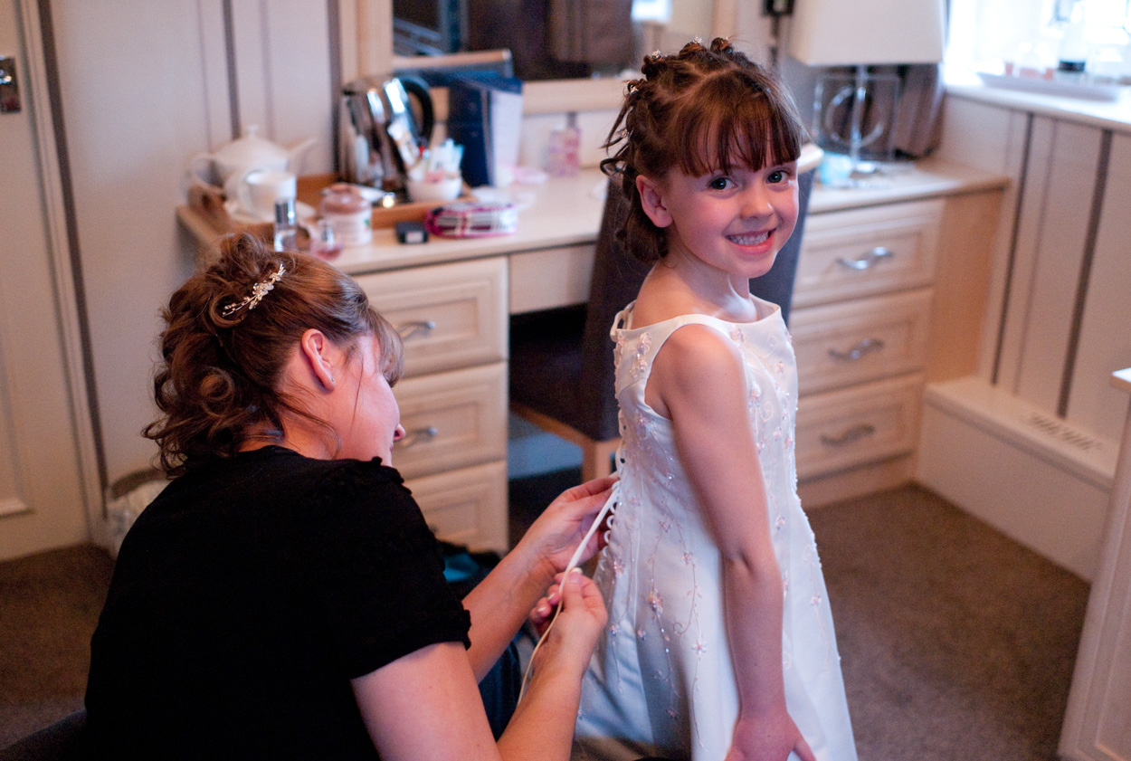 Mother of the bride tying her daughter’s bridesmaid dress laces