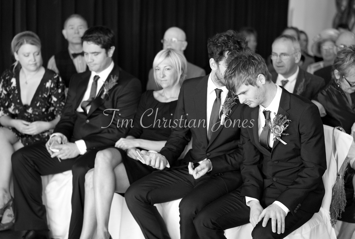 The best man whispering into the groom’s ear as they wait for the ceremony to begin at the Trafalgar Tavern.