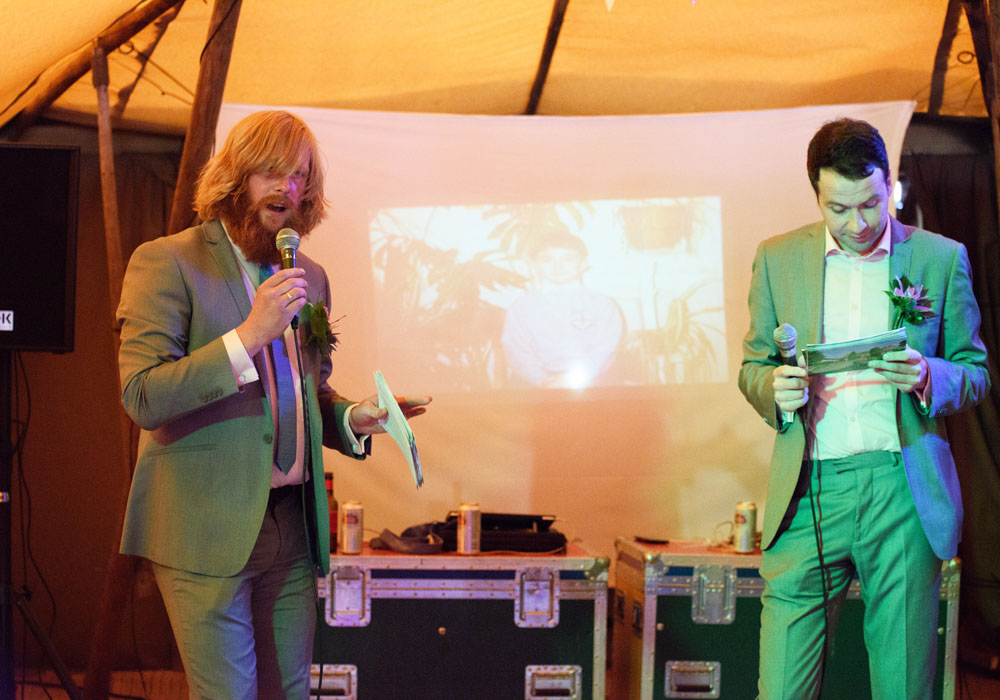 Both best men present a photo slideshow to the guests.