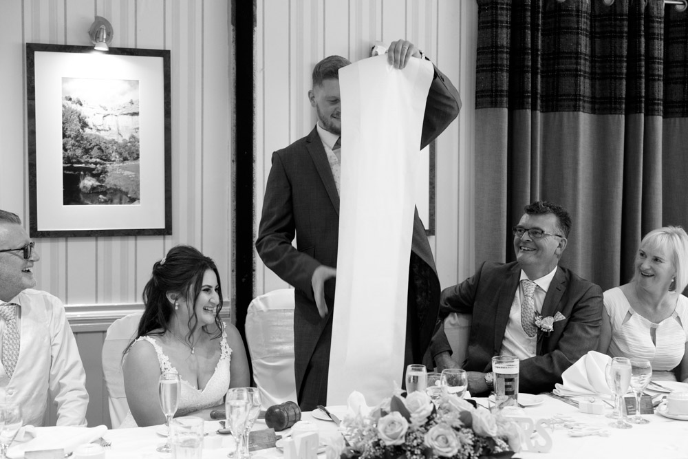 Matt holds up a long speech scroll, playfully unrolling about 1.5m of paper to laughter.