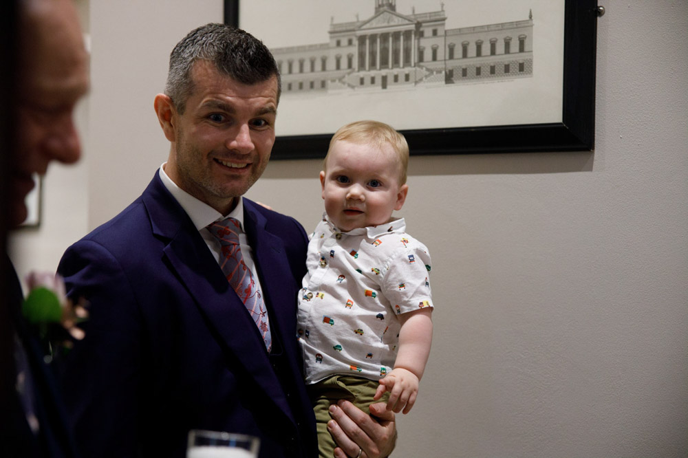 Father with his young son, who smiles directly at the camera.