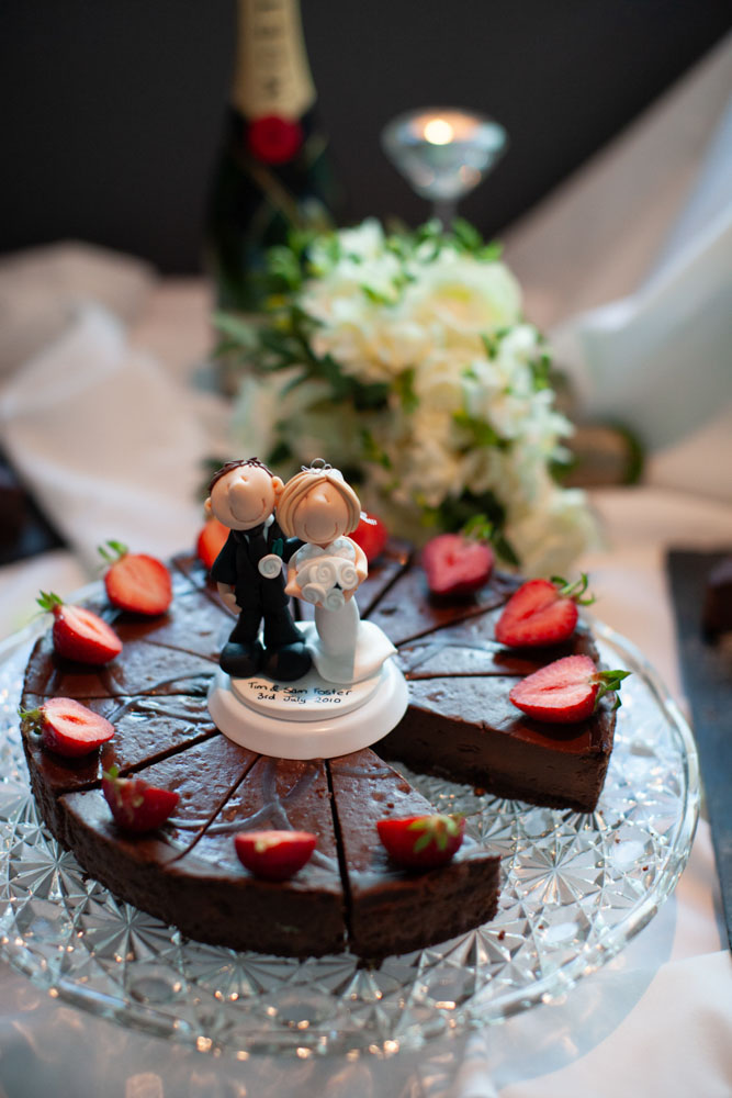 The chocolate cheesecake topped with strawberries and their restored cake topper, ready to admire again.