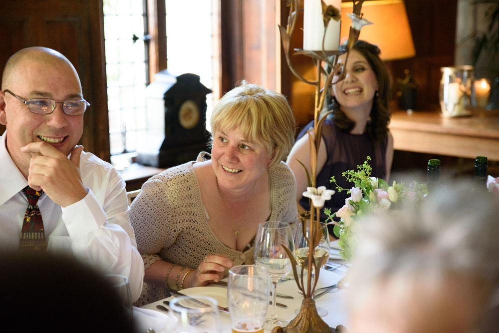 Guests react with smiles as the bride begins her surprise speech.