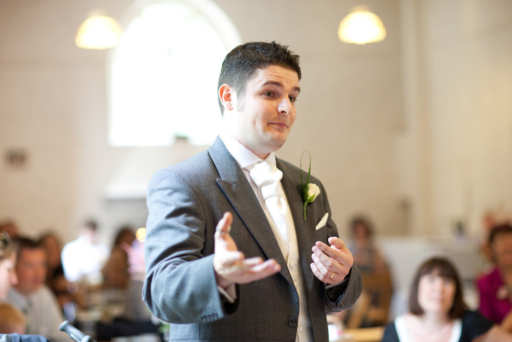 Best man mid-speech, laughing as he shares a story