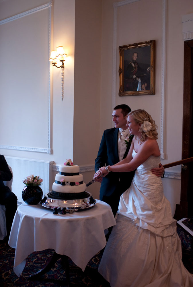 Dani and Scott hold the cake-cutting pose for guests’ photos