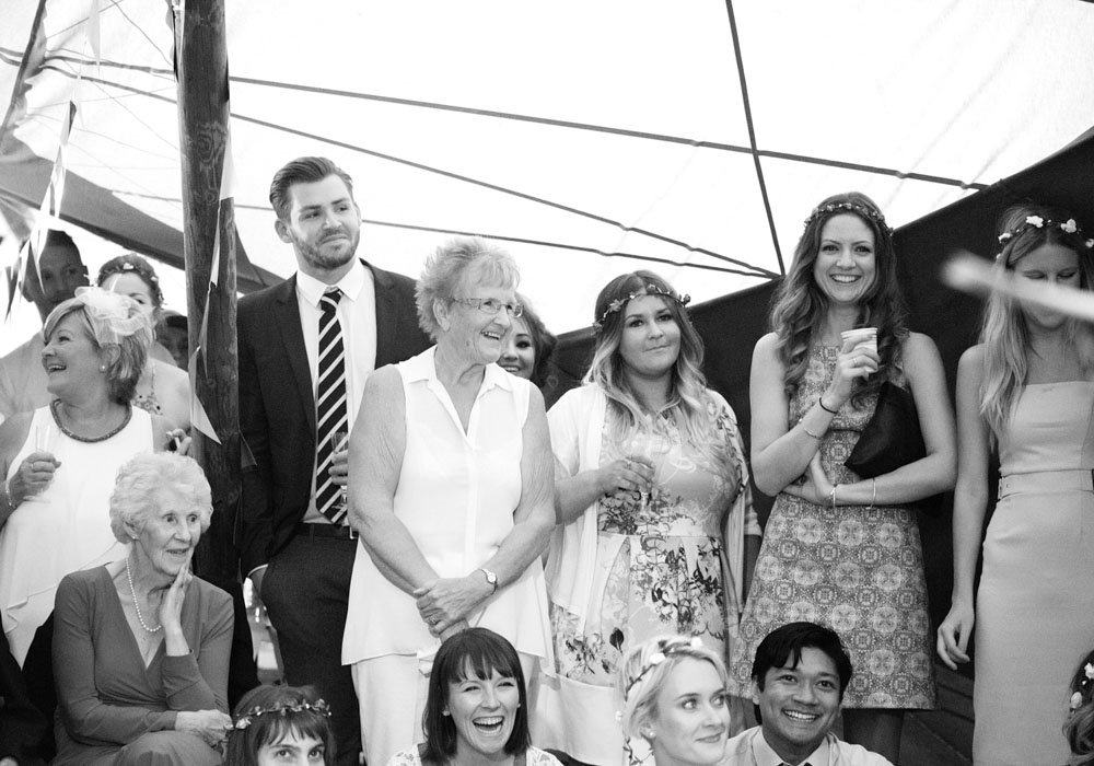 More wedding guests laugh together inside the West Yorkshire reception tent.