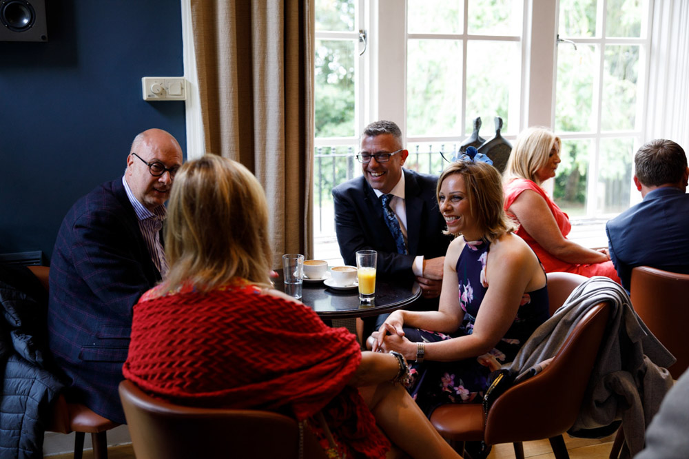Guests sitting in the lounge area, chatting and enjoying drinks.
