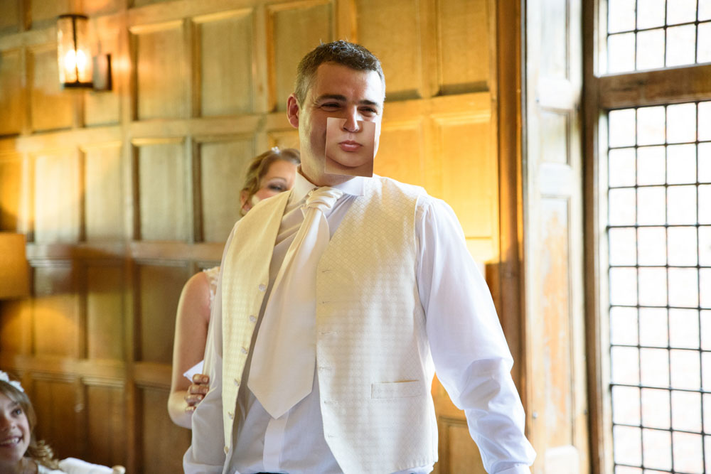 Groom wears a smile card joke, but his real grin shows underneath.