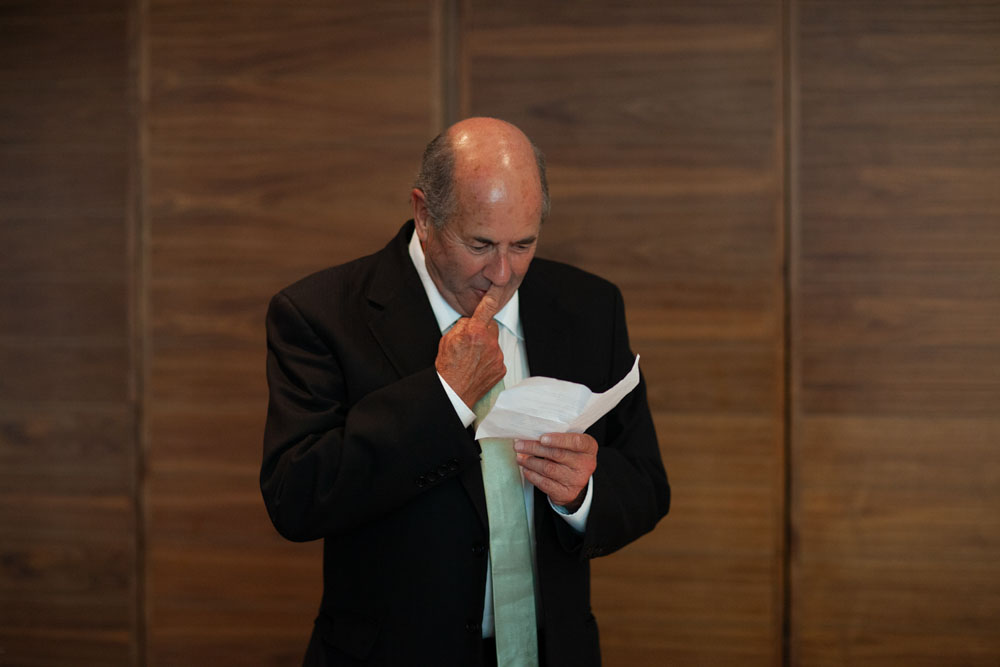 The father of the bride gives his speech, smiles across the room as he shares stories.