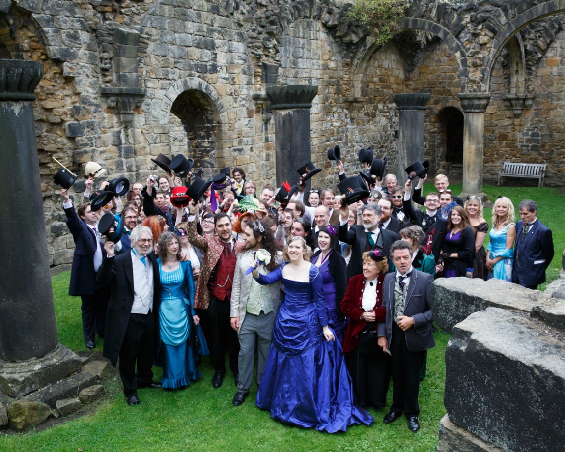 075 the gents raise their steampunk style bowler hats during the candid group photo kirkstall abbey wedding linsey and chris