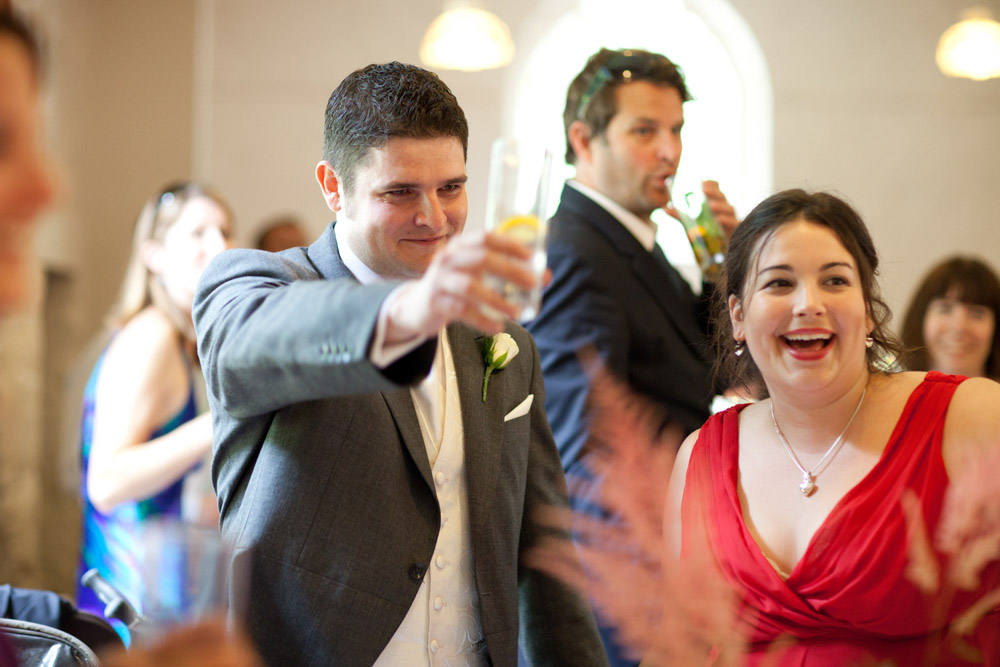 Best man raising a glass beside his girlfriend during the toast