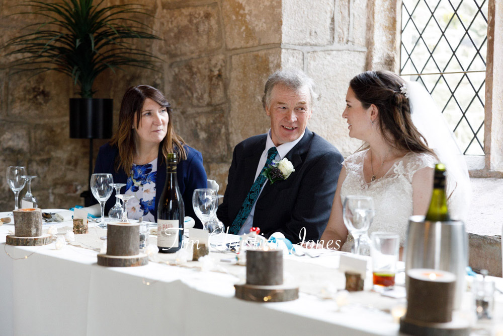 Natural wedding photo of bride chatting with parents at Barden Tower.