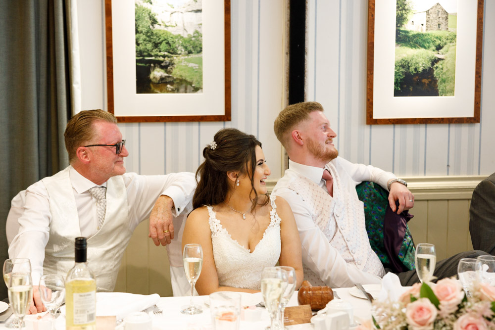Kyra and Matt laugh, reacting warmly to a speech with a touch of hesitation and humour.
Caption:
