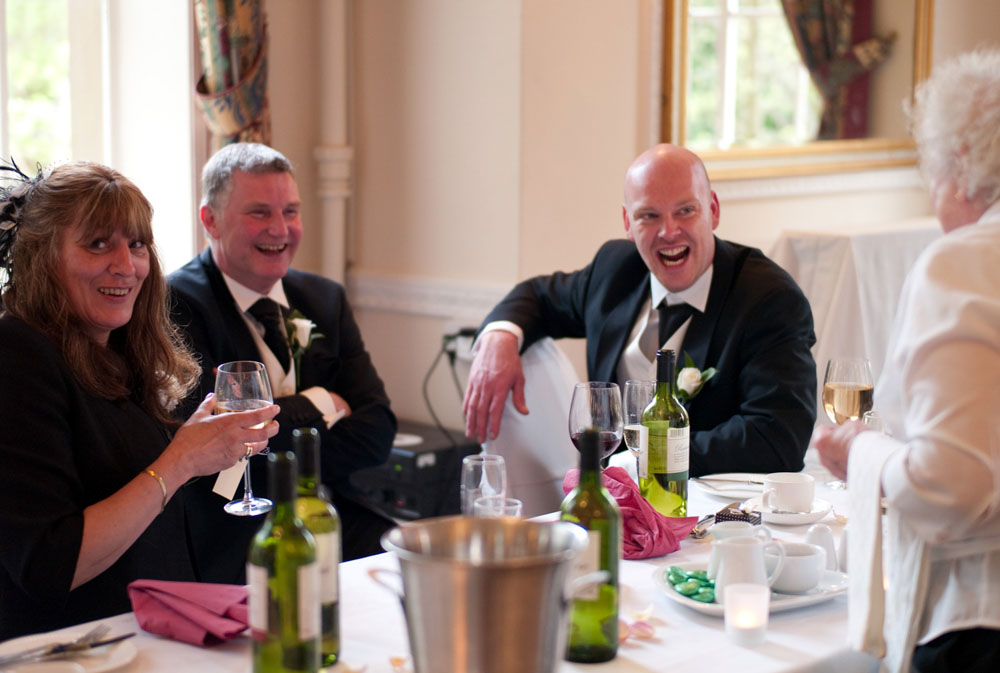 Guests smile toward the camera, noticing the photographer mid-moment