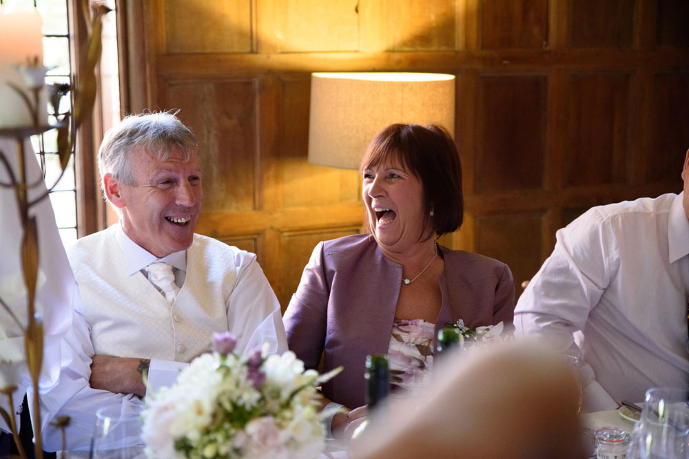 Top table guests laugh as the best man’s speech builds.