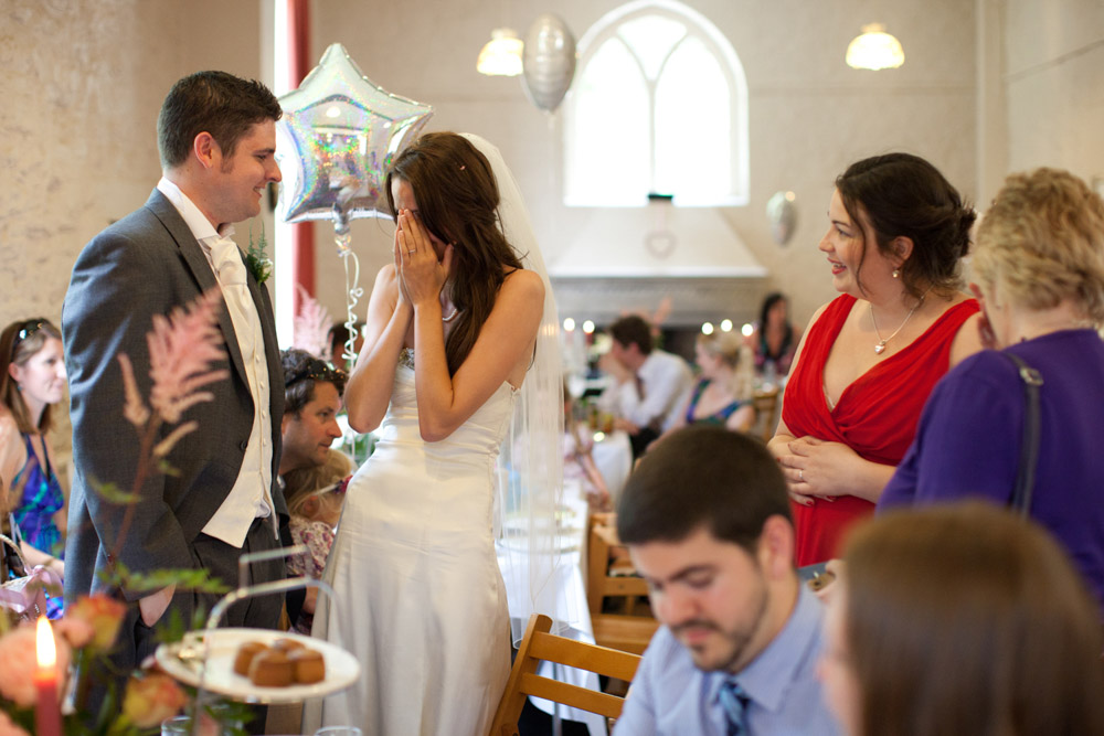 Lowri with her head in her hands mid-laughter at a lively table chat