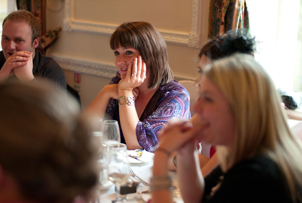 Guests seated at round tables, all smiling and engaged during the evening reception.