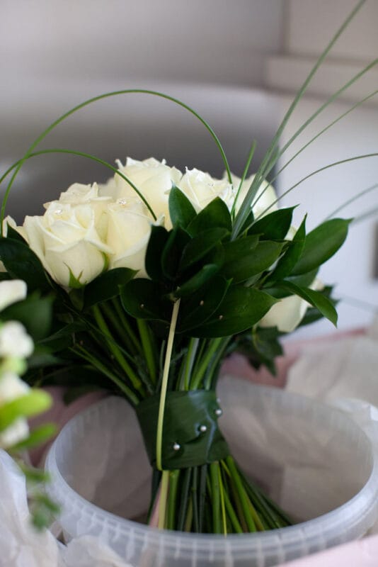 Rose and greenery bouquet resting in a clear bowl