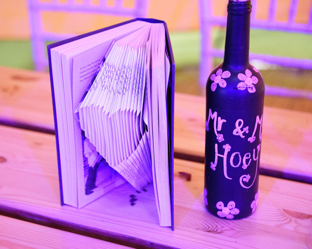 Heart shape carved into a book’s pages beside a painted “Mr & Mrs Hoey” bottle.