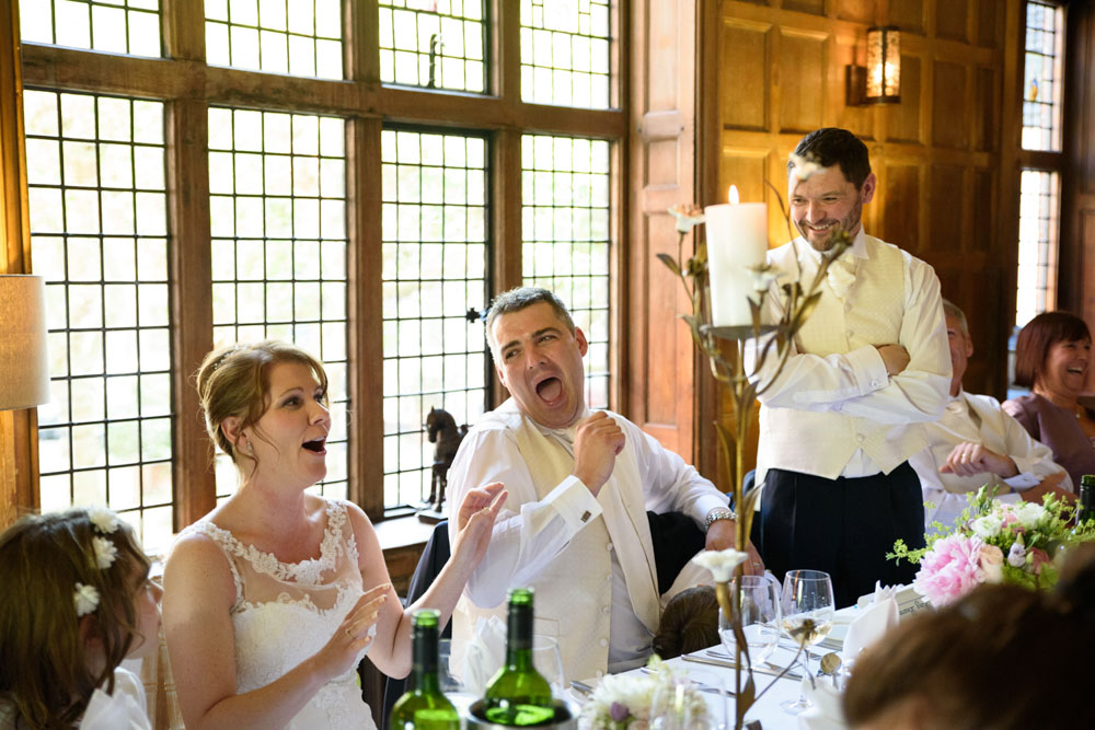 The couple burst into laughter as the best man ends his speech.