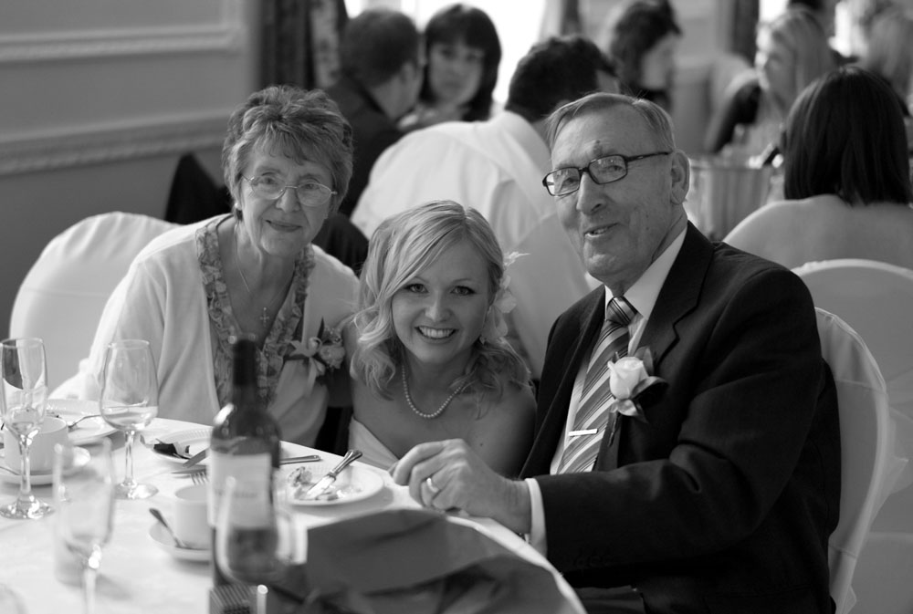Dani crouches down between two elderly guests for a heartfelt photo together.