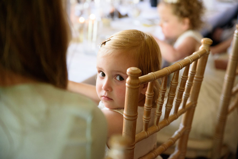 Little toddler turns to look at the camera as food arrives.
