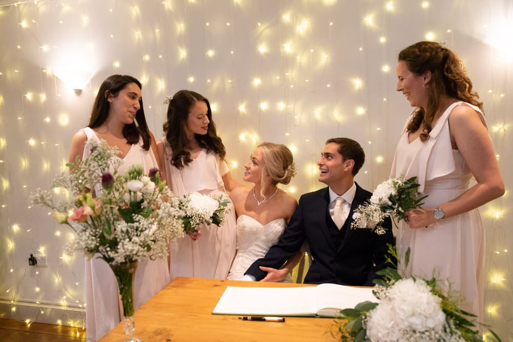 Bridesmaids share a lighthearted chat with Helen and Adam during a natural candid moment.