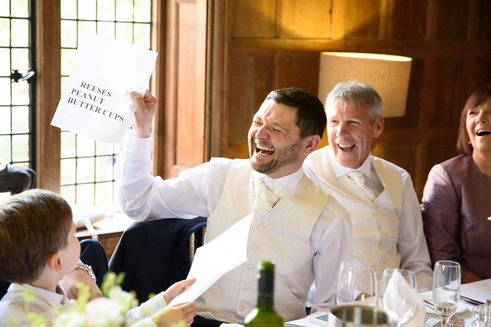 Best man laughing, holding up a private joke during his speech.