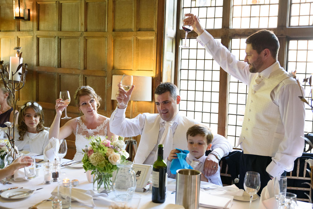 Best man raises a toast to the top table as his speech concludes.