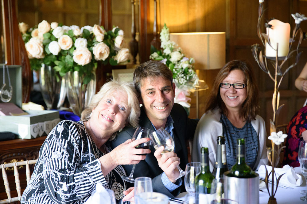 Guests clink glasses and smile at the camera during the toast.