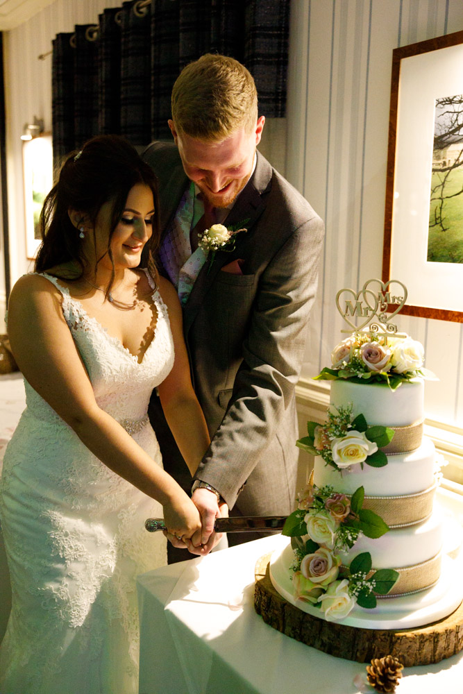 Kyra and Matt cut the cake naturally, smiling together under the available evening light.